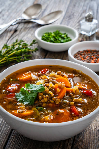 istock Fresh vegetable soup with lentil on wooden table 1975440628