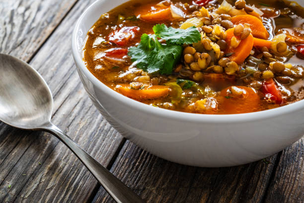 istock Fresh vegetable soup with lentil on wooden table 1975441144