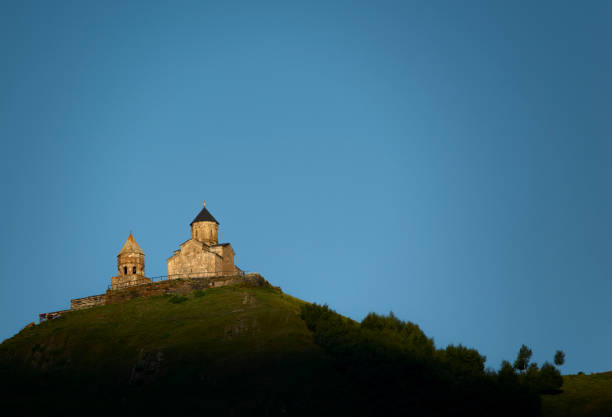 Gergeti Trinity Church against the blue sky, Stepantsminda, Kazbegi, Georgia.