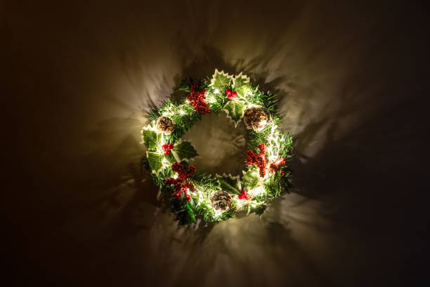 istock Christmas wreath with lighting garland hanging on a wall 1975479680