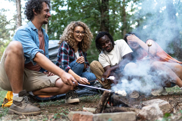 istock Cheerful young friends roasting marshmallows 1975486030