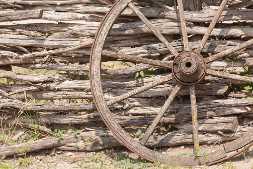 old wagon wheel on the wooden fence
