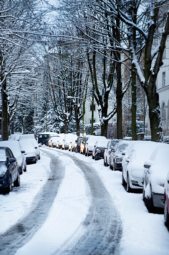Traffic on a snow-covered street in the city after heavy snowfall at dusk.