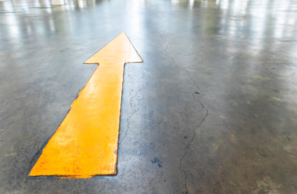 Yellow arrow on concrete road in building