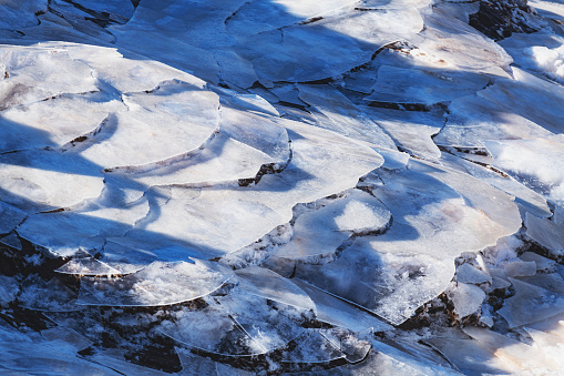 Layers of ice on a riverbank left by the receding tide.