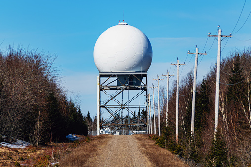 A narrow road leads to an airport radar dome.