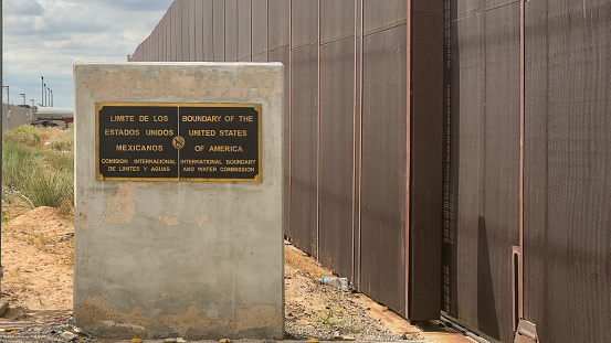 International Border Crossing in Santa Teresa New Mexico with Plaque Determining Border Line with Iron Border Wall in the Background