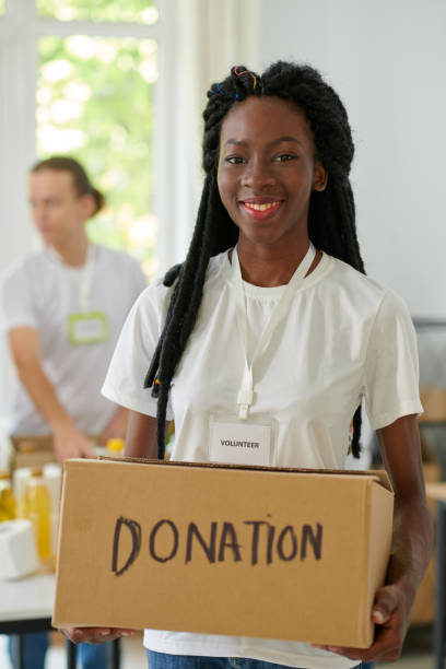 istock Woman Holding Box with Donated Products 1975579772
