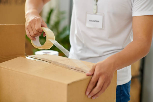 istock Volunteer Taping Boxes in Offic 1975580320