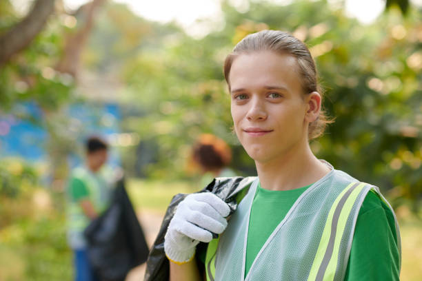 Portrait of smiling guy with big bag of collected garbage