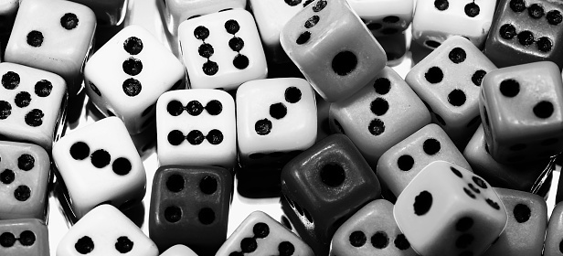 background of mini cubic six-sided gaming dice rolled for playing with balck and white effect