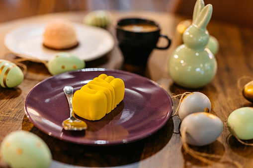 Mini desserts served with coffee on an Easter-themed table in a café. Yellow mini dessert that spells 