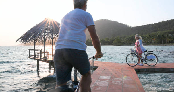 istock Couple ride bicycles along pier at sunrise 1975621372