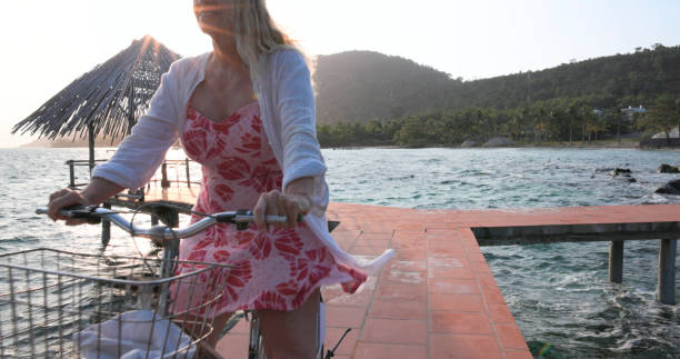 istock Senior woman rides bicycle on pier 1975622440