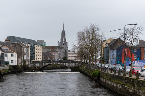 Tower of Catholic Cathedral on background of cityscape with River Lee. Ireland, Cork, January 24, 2024