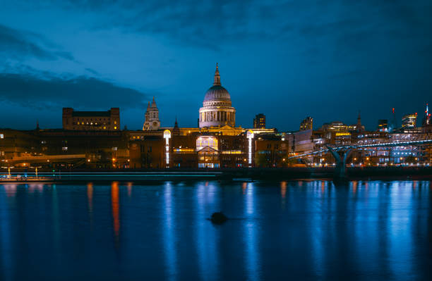 St Paul's Cathedral and Millenium Bridge at night in London, UK