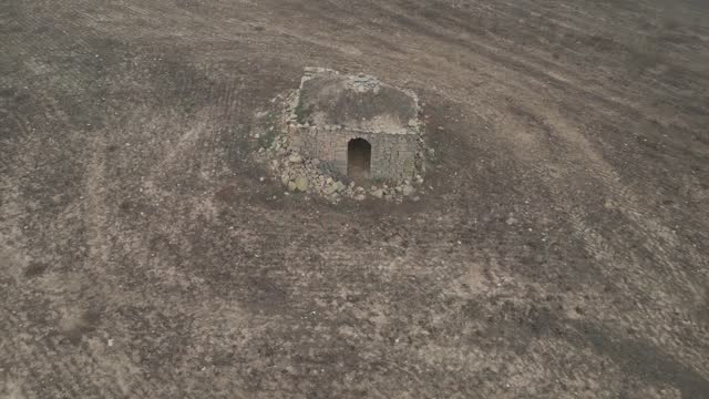 Old hermitage of Sant Esteban in ruins in middle of arid field, aerial view