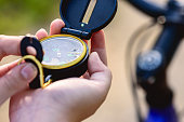 During bikepacking tour girl checking compass to choose the next turn