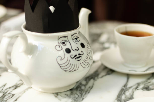 Fancy king teapot on marble tabletop, white teapot and teacup with drink hot english tea.