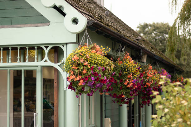 hanging flower baskets on the eaves of a structure, moss growing on the roof and lovely architectural details. room for copy.