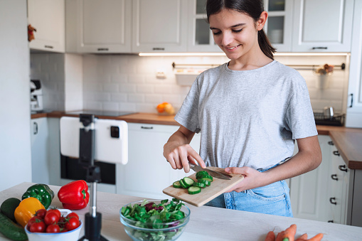 Healthy food vlog. Teenage girl preparing meal at home