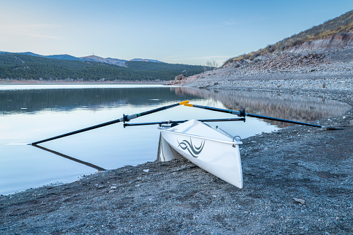 Loveland, CO, USA - January 30, 2024: Coastal rowing shell by Liteboat on a shore of Carter Lake in northern Colorado at dusk in winter scenery