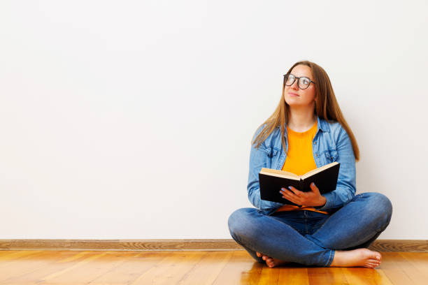 istock Young Woman Contemplating While Reading a Book 1975763330