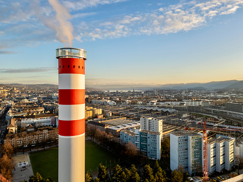 Chimney of the waste incineration plant on Josefstrasse Zürich with smoke and the city in the background