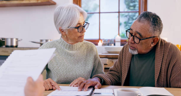 istock Couple, documents and reading for insurance in retirement, planning and bills or paperwork. Senior people, marriage and communication or discussion for future, saving and finance in kitchen at home 1975775649