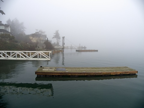 Ocean dock covered in dense fog during winter time in Greater Victoria, BC
