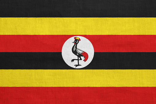Flag of Republic of Uganda on a textured background. Concept collage.
