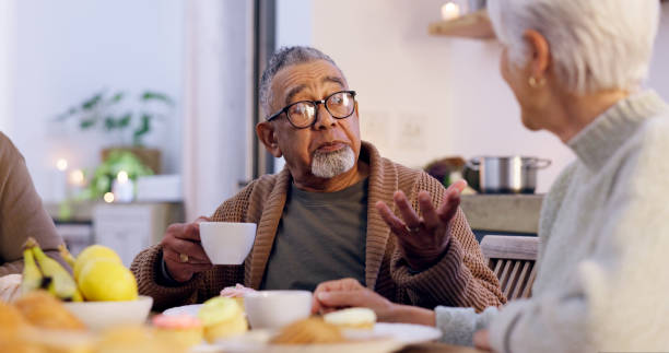 istock Senior couple, drinking coffee and conversation at home, discussion and talking at dinner table. Elderly people, communication and speaking at night, meal and eating food together, talk and bonding 1975776219