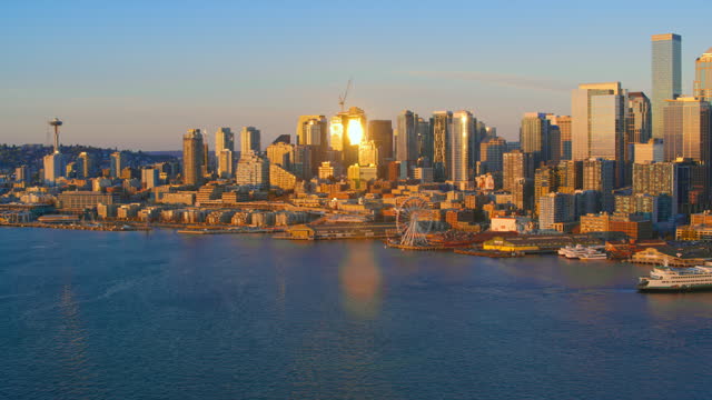 AERIAL Seattle waterfront in golden light of the setting sun