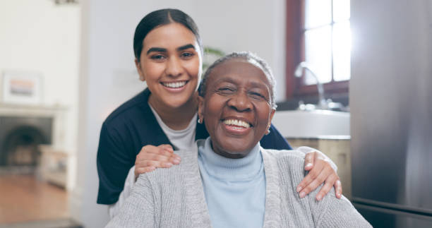 smile, healthcare and portrait of nurse with patient in a wheelchair for discussion at nursing home. medical career, happy and young female caregiver with senior black woman with disability in house. - ouderenzorg stockfoto's en -beelden