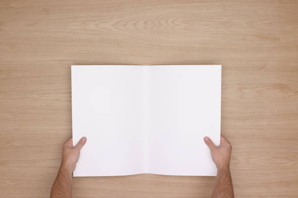 istock Two Hands Holding Open A Blank Magazine. 1975830693