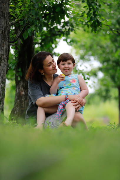 istock mother daughter sitting under the tree 1975831197