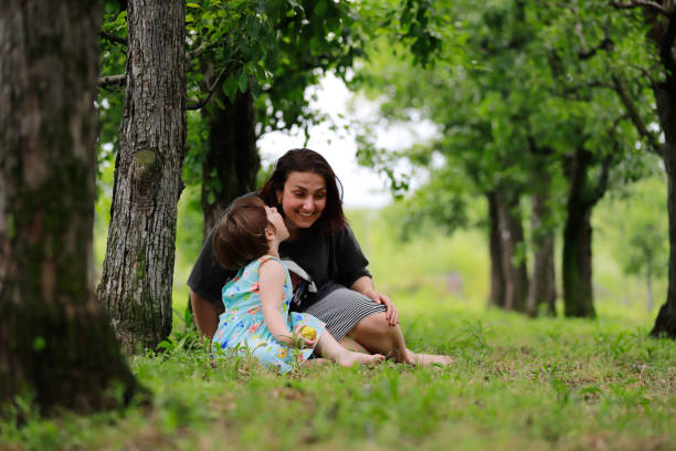 mother daughter sitting under the tree