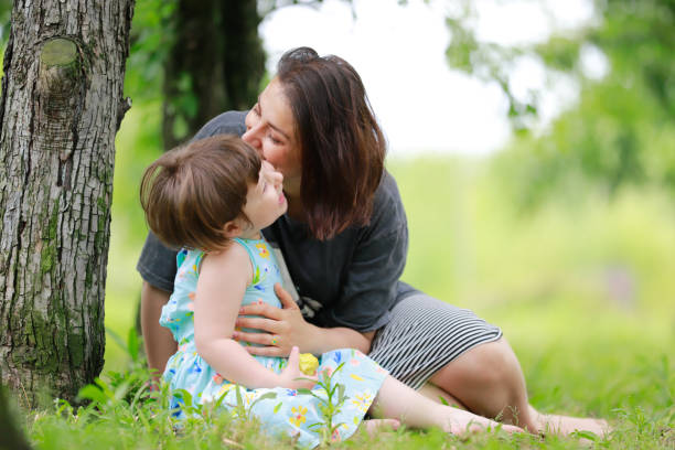istock mother daughter sitting under the tree 1975832786
