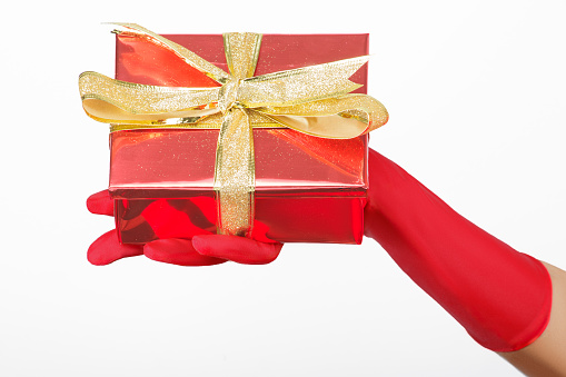 Woman's Hand with Red Glove Holding a Gift on a White Background