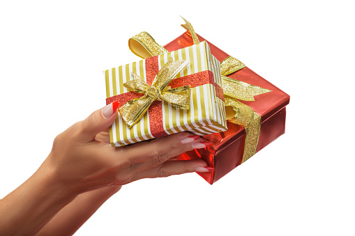 Woman's hands holding gifts against a white background
