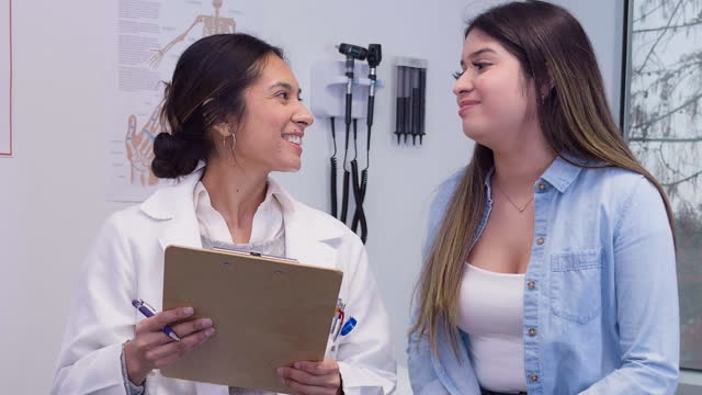 Female pediatrician consoles anxious patient after medical exam
