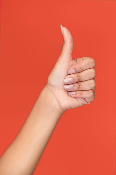 istock Isolated hand on an orange background with the thumb up 1975930126