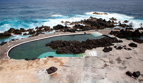 Floating bench seat, sitting zone in swimming pool with clean clear water, nobody. Square shaped pool with blue tiles, no people. Summer background.