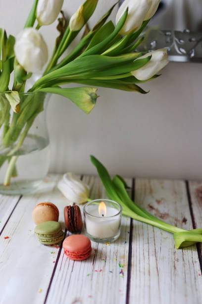 istock Romantic still life with a candle, macarons and tulips 1975976025