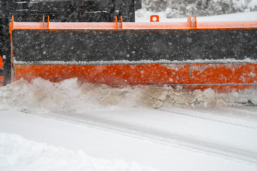 close up on snowplow driving on residential street