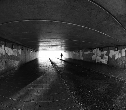 Young man walking through a run down urban tunnel