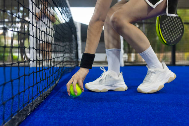 istock Young person bending down to pick up the ball 1976043418