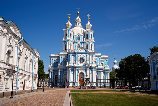 Saint Petersburg, Russia - June 08, 2023: Smolny Cathedral built in 1748-1835 as orthodox Voskresensky of all educational institutions, summer sunny day. Unrecognizable people