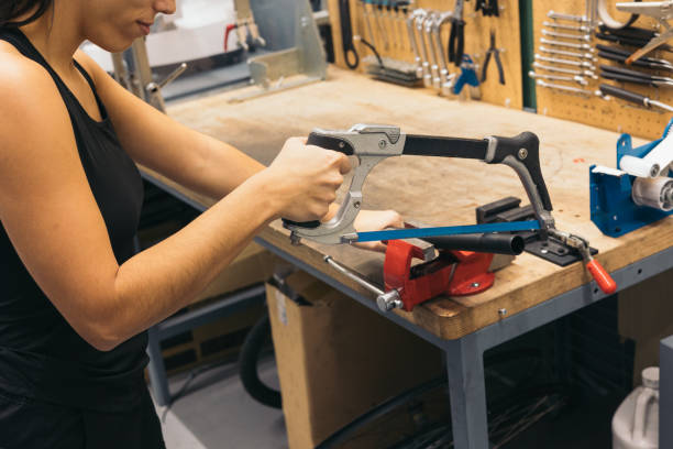 istock mechanic girl cutting pipe in workshop 1976057900