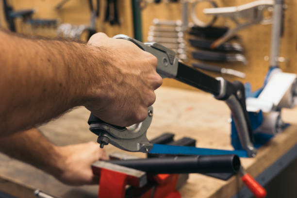 istock closeup of hand cutting a pipe with saw in workshop 1976057910